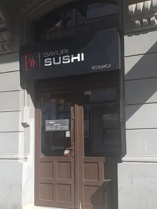 Wejście z czarnym szyldem SUSHI